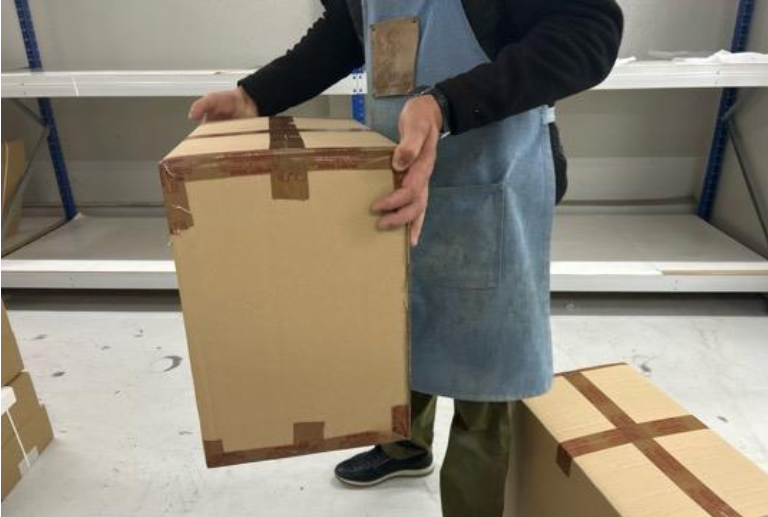 Quality inspection performing a carton drop test to assess packaging resistance and product protection