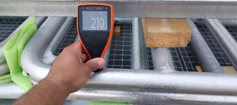 Galvanizing quality inspection verifying coating on a steel structure using measurement and visual checks