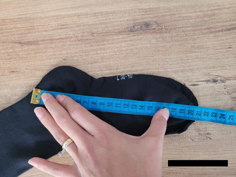 Quality inspection measuring the thickness of a wooden board using a digital caliper during on-site inspection